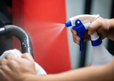 Vaporisateur bleu et blanc désinfectant un équipement de gym pour la sécurité sanitaire