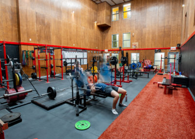 Vue intérieure spacieuse d'une salle de musculation avec des équipements d'haltérophilie variés