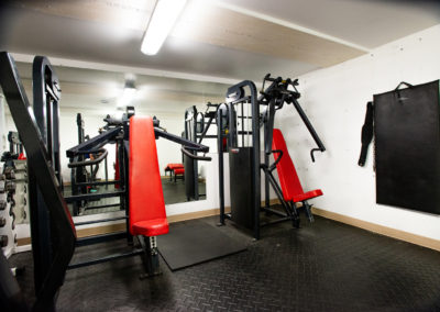 Salle de musculation propre avec des équipements d'exercice rouge et noir